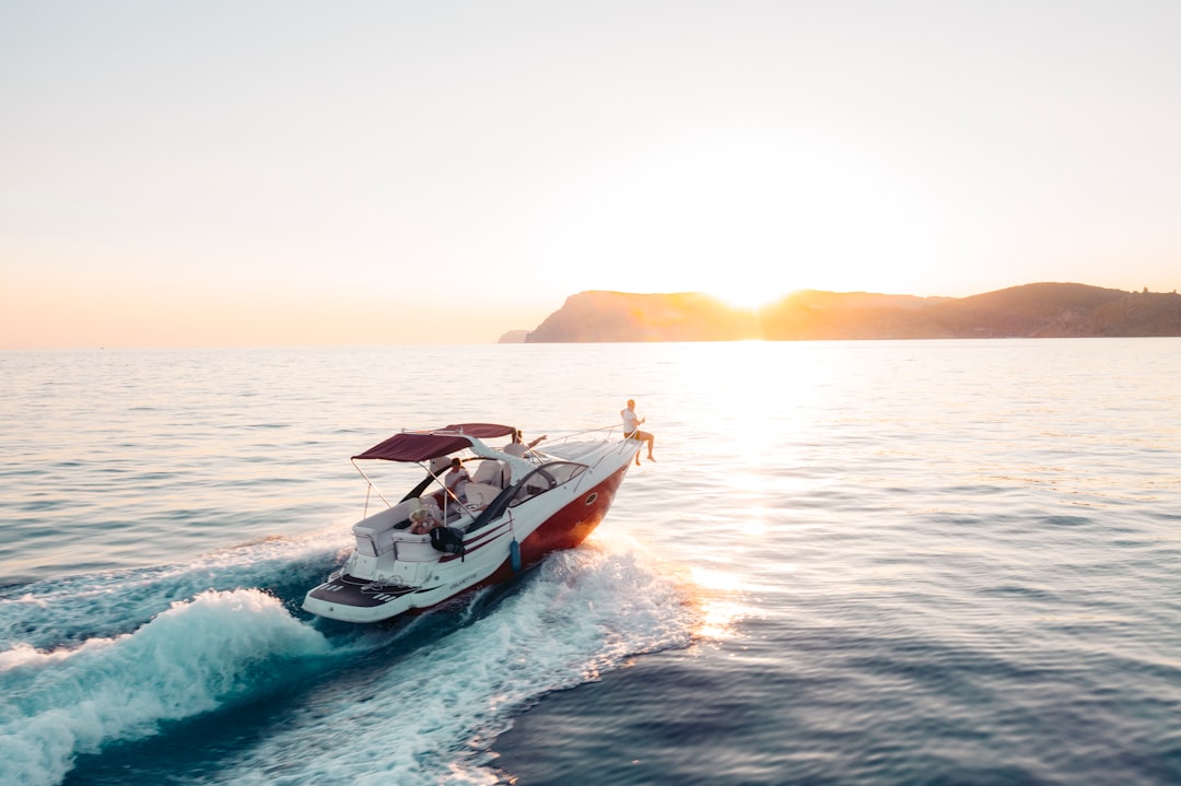 A recreational boat cruising on calm open water under clear blue skies