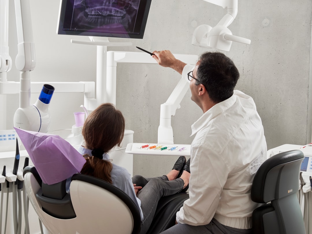 Smiling patient in dental chair reviewing dental insurance coverage options